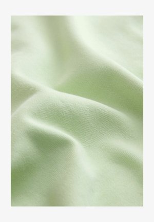 Material moale, verde pal, cu o textură fină de tricotaj vizibilă și falduri delicate care creează unde line și fluide pe suprafață.