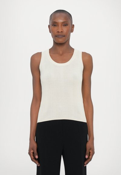 Débardeur crème à côtes avec un col rond et sans manches, présentant une surface texturée et une silhouette ajustée.