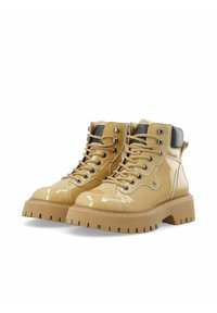 Bottes ankle en cuir verni khaki avec une semelle épaisse et robuste, un système de laçage et des accents métalliques. Présente des détails de talon et de couture contrastés.