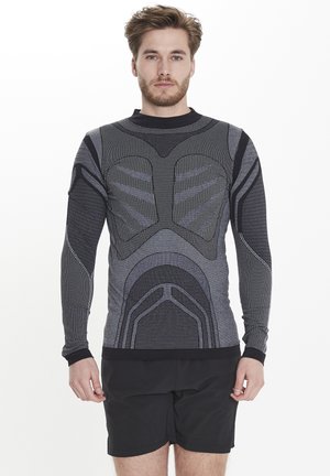 T-shirt de sport à manches longues en noir et gris, avec un design texturé présentant des motifs géométriques et une coupe ajustée.