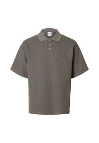 Polo à manches courtes en gris doux, fabriqué à partir d'un tissu doux et texturé. Présente un col classique et une patte de boutonnage à trois boutons.