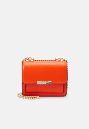 Petit sac à main rectangulaire en cuir orange avec une bandoulière chaîne dorée et un fermoir doré gravé du nom de la marque.