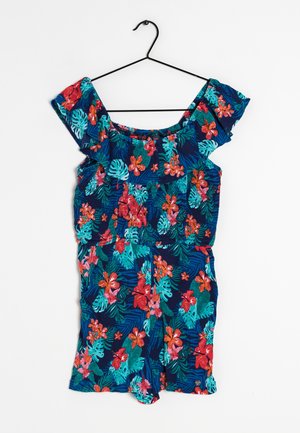 Květinový overal s tmavě modrým pozadím, zdobený výraznými růžovými a tyrkysovými květy, s volánkovými rukávy a přiléhavým pasem.