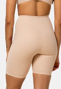 Beige korte broek met hoge taille, gemaakt van gladde, rekbare stof. Heeft een naadloos ontwerp en een geribbelde zoom voor comfort en pasvorm.