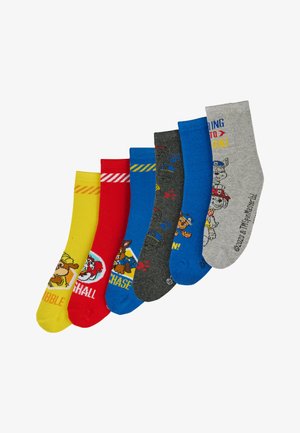 Cinco pares de calcetines coloridos: amarillos con un perro de dibujos animados, rojos con rayas, azules con huellas de patas, grises con un perro y grises con texto.