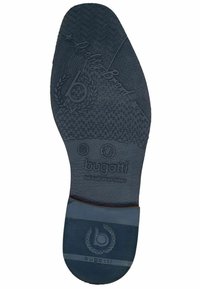 Dunkelblauer Gummischuhsohle mit strukturierten Griffmustern, eingeprägtem Markennamen "bugatti" und Größenmarkierungen. Flache, abgerundete Form mit Designakzenten.