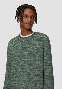 Groene gebreide trui met een ronde hals en lange mouwen. Bevat een gemixt patroon dat diepte en visuele interesse biedt.
