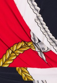 Tkanina w wielu kolorach z czerwonymi, granatowymi i białymi sekcjami, ozdobiona złotym wzorem sznura i srebrnymi akcentami, o delikatnej fakturze.