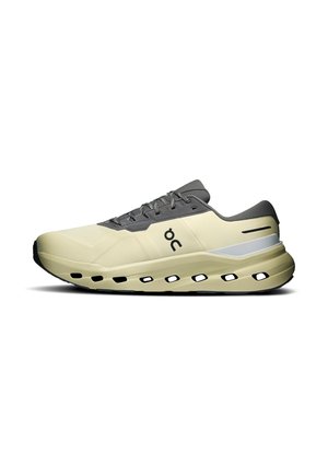Chaussure de course beige clair et grise avec logo noir, semelle perforée et design à lacets vue de côté sur fond blanc.