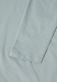 Hellblau gestreifter Stoff mit einer weichen Textur, sauber verarbeiteten Kanten und dezenten horizontalen Linien über die gesamte Oberfläche.