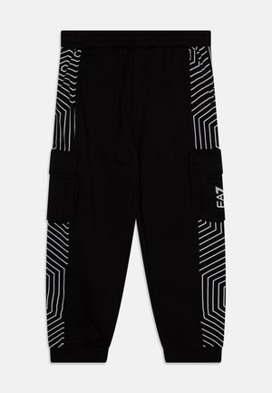 Schwarze Cargo-Hosen mit weißen geometrischen Streifenmustern an den Seiten, elastischem Bund und Seitentaschen. Hergestellt aus weichem, flexiblem Material.