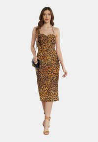 Abito midi con stampa leopardata in tonalità di marrone e arancio, con silhouette aderente, scollatura a cuore e spalline all'americana, abbinato a una borsa nera.