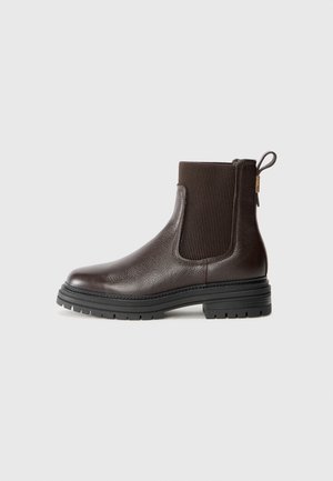 Bota de tornozelo em couro castanho com painéis laterais elásticos, superfície texturizada e bico redondo. Apresenta uma sola grossa de borracha e um puxador.