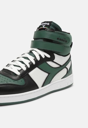 High-top sneaker med grønne, sorte og hvide paneler, hvide snørebånd, dobbelte grønne ankelsnore og en hvid sål på ensfarvet baggrund.