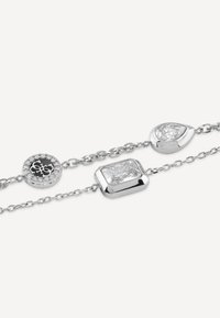 Bracciale d'argento con tre pietre distinte: rotonda con accenti neri e trasparenti, rettangolare e a forma di goccia, tutte con una finitura lucida.