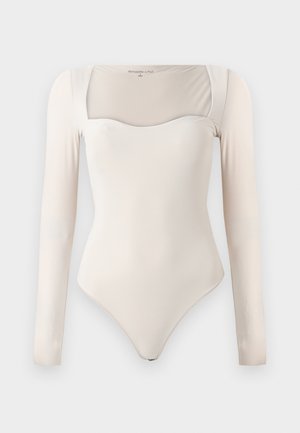 Bodysuit beige à manches longues avec une encolure carrée et une silhouette ajustée, présenté sur un fond uni.