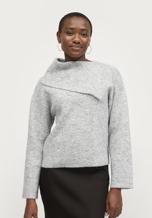 Lichtgrijze gebreide trui met een gevouwen kraag, lange mouwen, afgeronde zoom en een zachte textuur, gecombineerd met een donkere rok.