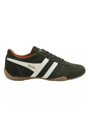Zapatilla deportiva de ante verde oscuro con rayas laterales blancas, suela marrón y interior naranja, con cordones y la marca "Gola" en el lateral.