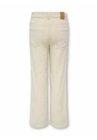 Pantalon en velours côtelé beige avec des jambes droites, poches arrière, passants de ceinture et une petite étiquette en cuir marron sur la taille.