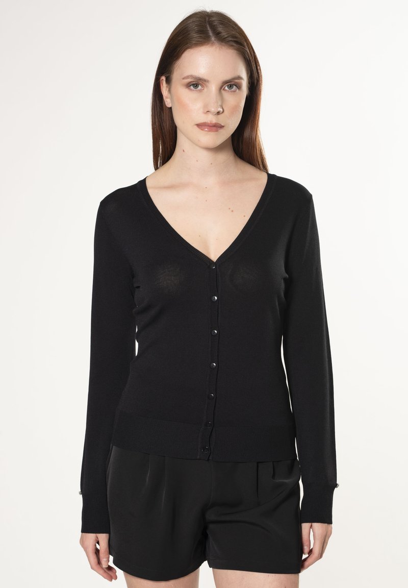 Cardigan nero a maniche lunghe con scollo a V, chiusura a bottoni, polsini a coste e silhouette aderente. Texture liscia senza motivi visibili.
