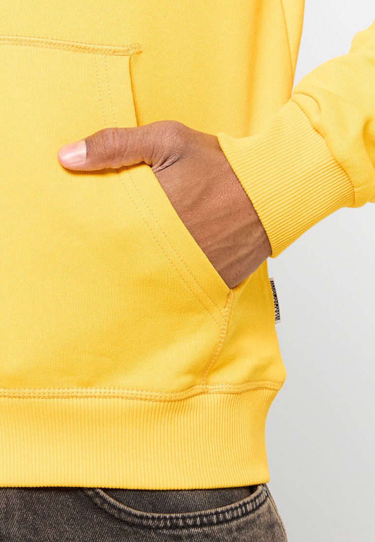 Felpa gialla con tasca a marsupio frontale, polsini e orlo a coste. Tessuto morbido e liscio con dettagli di cucitura visibili.