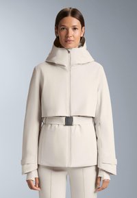 Bež jakna skraćena do struka s oblikovanim kapuljačom, zatvaranjem na patentni zatvarač i pojasom u struku. Ima široke rukave i glatku, teksturiranu tkaninu.