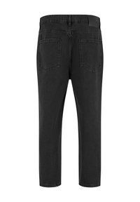 Czarne dżinsy z denimu widoczne od tyłu, z dwoma naszywanymi kieszeniami, szlufkami na pasek oraz prostymi nogawkami na białym tle.