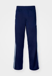 Pantalones deportivos de color azul marino con cinturilla elástica, adornados con rayas laterales de color azul claro y una textura de tela suave y ligeramente brillante.