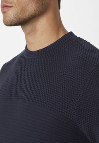 Navy-blauer strukturierten Pullover mit rundem Ausschnitt und einem kontrastierenden glatten horizontalen Band im Brustbereich.