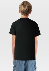 Svart bomullströja med korta ärmar och rund halsringning. Bakifrån syns en slät textur och enkel design, perfekt för avslappnad klädsel.