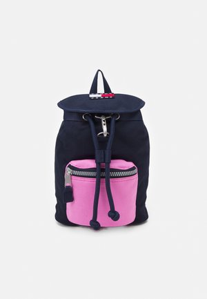 Kompakt rygsæk i marineblå med en lyserød lynlåslomme foran, snorelukning og et lille rødt, hvidt og blåt logomærke på toppen.