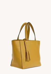 Sac fourre-tout en cuir jaune avec double poignées et un détail de pompon assorti sur fond blanc.