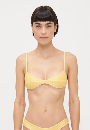 Yellow bikini top with thin straps, a triangular shape, and smooth fabric. Delicate stitching along the edges and a minimalist design.