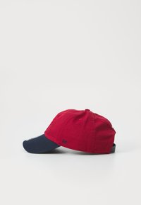 Caciulă de baseball din bumbac roșu, cu visieră de culoare bleumarin, având logo brodat și găuri de ventilație, curea ajustabilă în spate.