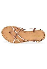 Sandale en cuir marron avec des brides croisées, des accents métalliques et des détails cousus. Elle dispose d'une semelle intérieure confortable et d'une bride de cheville réglable.
