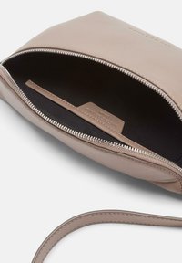 Skórzana torba na ramię w kolorze brązowym z zamkiem błyskawicznym, charakteryzująca się gładką fakturą, wewnętrzną kieszenią oraz materiałowym podszewką. Pasek jest zintegrowany i elegancki.