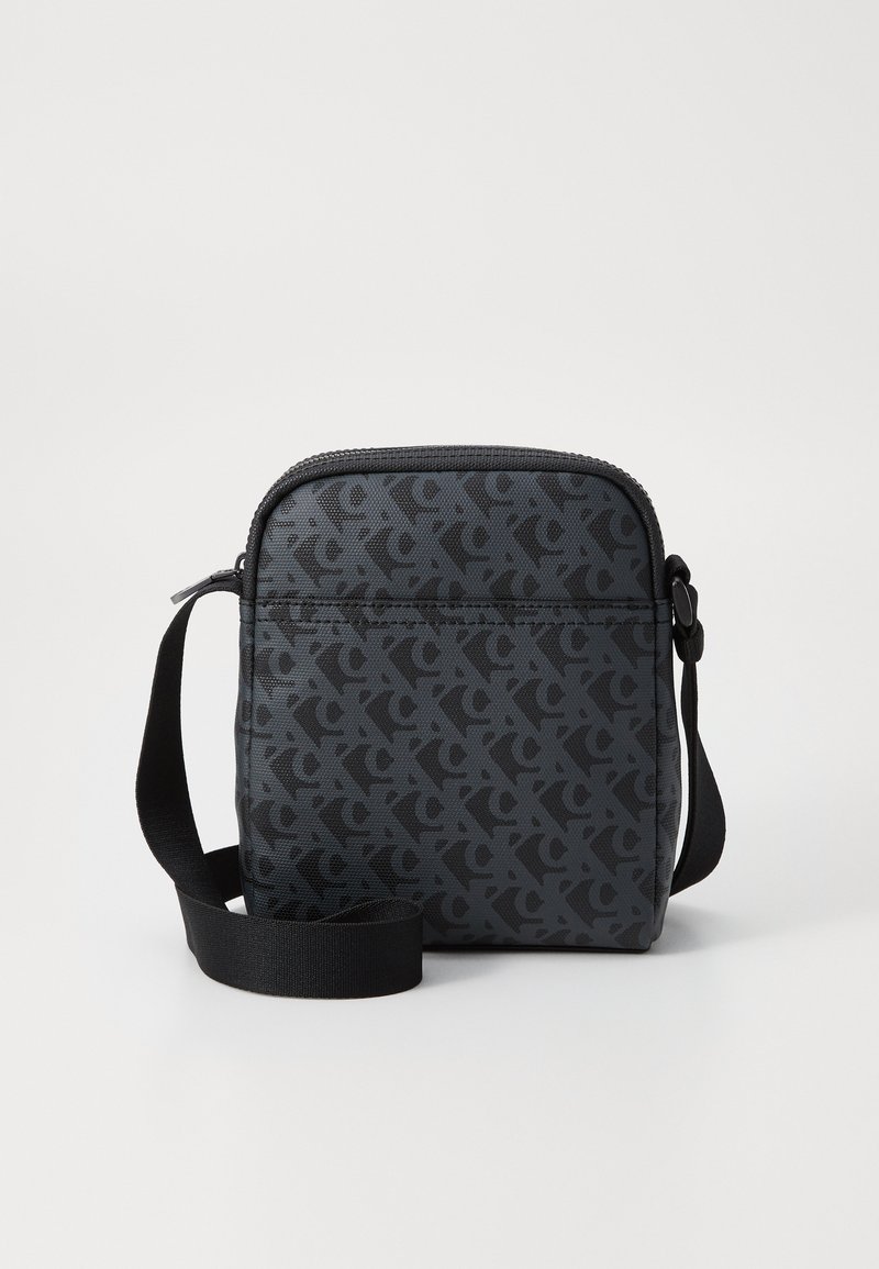 Geantă neagră tip crossbody cu finisaj texturat, având un model repetat de logo de culoare gri închis, închidere cu fermoar și curea ajustabilă.