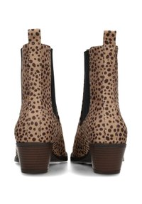 Botines con un patrón de manchas marrón y beige, paneles laterales elásticos, tacones bajos y una superficie texturizada.