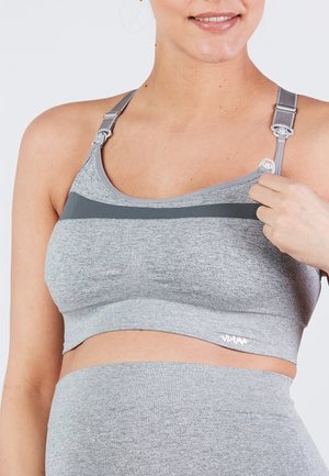 Soutien-gorge de sport gris avec des bretelles ajustables, présentant un tissu texturé et des rayures horizontales. Une bande élastique sous la poitrine affiche le logo.