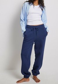Mörkblå sweatpants i mjukt material, med elastisk midja och snörning, sidofickor och avsmalnande muddar.