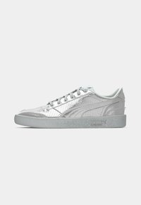 Sidevinkel af en sølvfarvet low-top Puma sneakers med perforeret detaljering og grå gummisål på en ensfarvet baggrund.