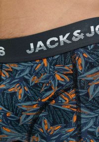 Mehrfarbige Boxershorts mit einem dunkelblauen Grundton und einem orangenen Blättermuster. Schwarzer Bund mit weißem "JACK & JONES"-Text. Glatte Textur.