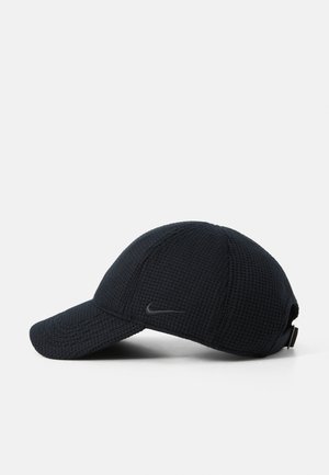 Black textured cap with a curved visor, featuring a subtle logo on the side and an adjustable strap at the back.