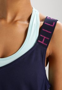 Navy and light blue tank top featuring a wide navy strap with pink lettering. Smooth fabric, athletic cut, layered design with contrasting colors.