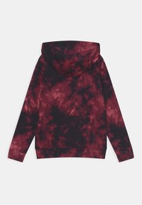 Sweat à capuche dans un motif tie-dye noir et rouge profond, avec des manches longues, une poche kangourou et des poignets côtelés.