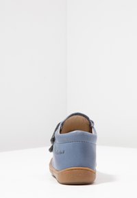 Modrá kožená bota s hnědou gumovou podrážkou, s texturovaným svrškem, šněrováním a malým logem na boku.