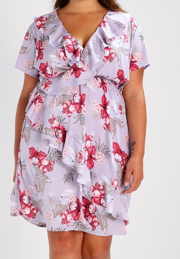 Kevätmekko vaaleanlaventelin värissä, jossa on punaisia ja valkoisia kukkia. Mekossa on röyhelöhiha ja -helma, v-aukko ja kerroksellinen röyhelöyksityiskohta vyötäröllä.