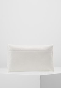 Biała skórzana saszetka o gładkiej fakturze, prostokątnym kształcie, subtelnych detalach przeszycia oraz zamknięciu na zamek błyskawiczny u góry.