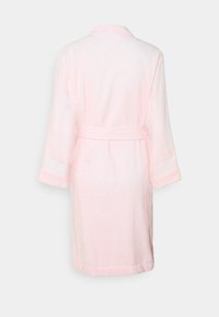 Accappatoio rosa chiaro con una consistenza morbida, maniche lunghe, una cintura legata e righe orizzontali sui polsini. La vista posteriore mostra una vestibilità rilassata.