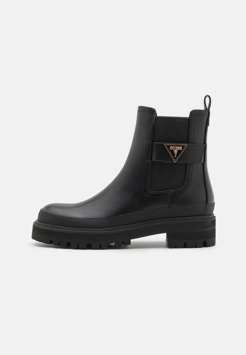 Bottines en cuir noir avec une finition lisse, des panneaux latéraux élastiques, une semelle en caoutchouc épaisse et un accent en logo triangulaire doré.
